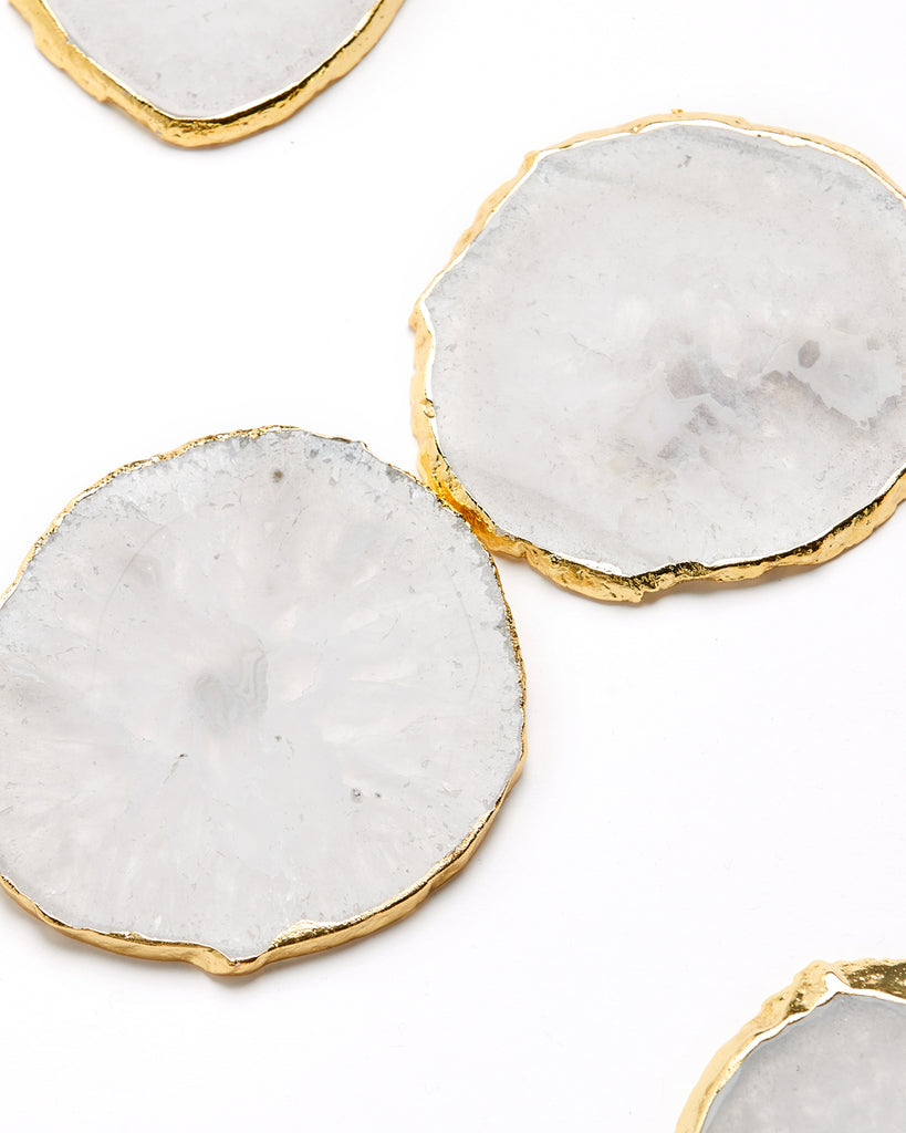 Gold plated white agate crystal coaster. Our natural crystal coasters are the perfect addition to your dining room or coffee table. With natural White Agate from Brazil, coated in yellow gold plating, this coaster is an easy way to elevate the luxury in your home.  White Agate Crystal  100-120mm  Gold Plating  Please note: Due to our crystals being 100% natural, shape and colour patterns will vary.