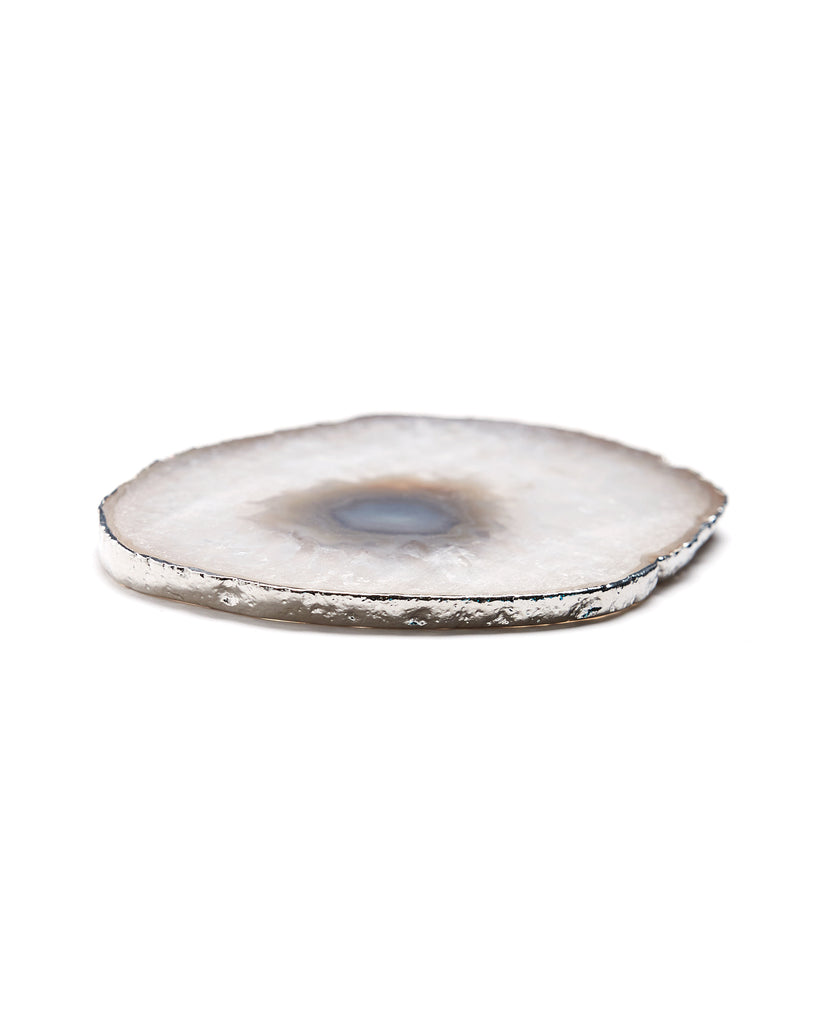 Silver plated white agate crystal coaster. Our natural crystal coasters are the perfect addition to your dining room or coffee table. With natural White Agate from Brazil, coated in silver plating, this coaster is an easy way to elevate the luxury in your home.  White Agate Crystal  100-120mm  Silver Plating  Please note: Due to our crystals being 100% natural, shape and colour patterns will vary.   
