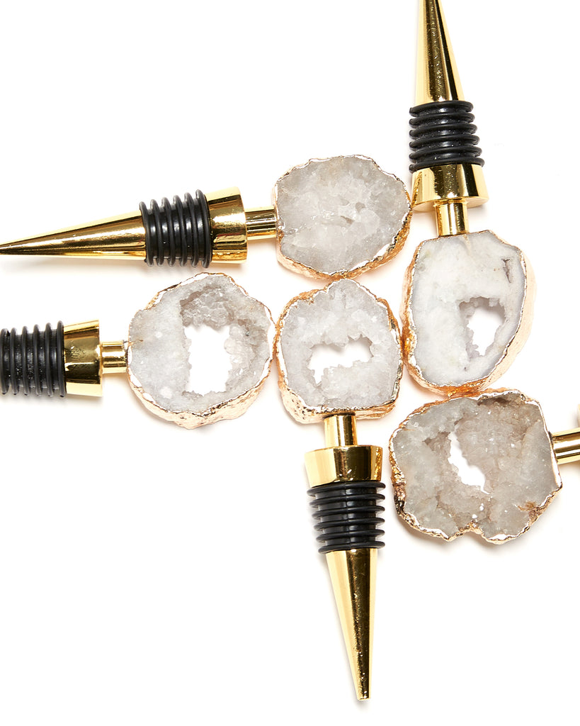 Mini gold plated white geode bottle stopper. Everything you loved about our crystal bottle stoppers, but MINI   Our natural crystal bottle stoppers are a lovely accessory to add to your bar stool when you're entertaining or for your nights in, to add some extra elegance. With natural Geode Crystal, coated in yellow gold plating, this bottle stopper is perfect as a unique table decoration. Yellow Gold Plating  9-11 cm  Note: Due to our crystals being 100% natural, shape and colour patterns will vary.