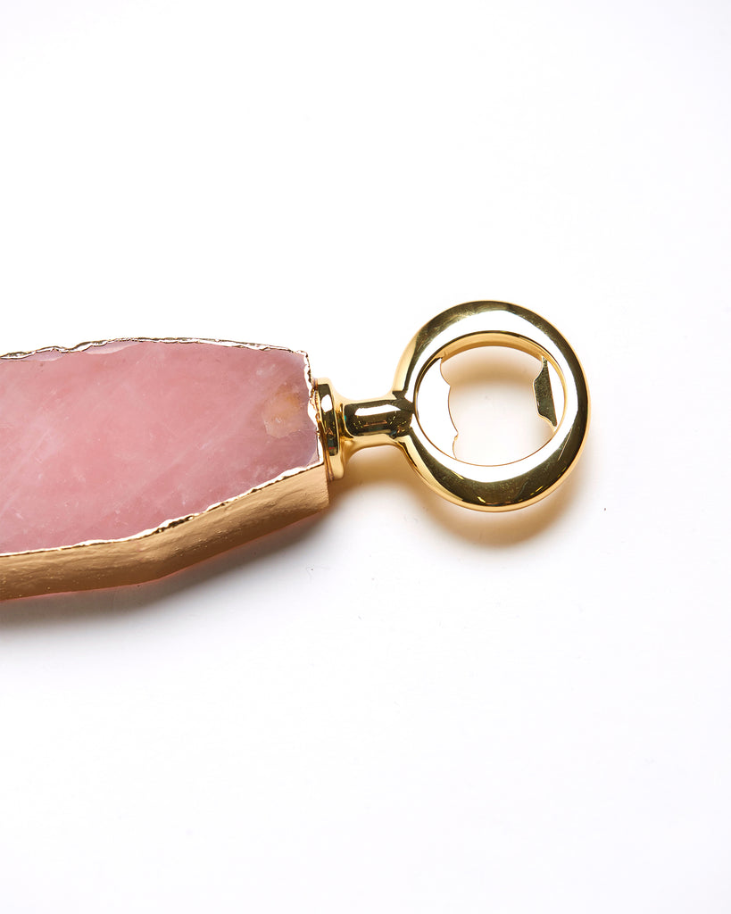 Detail view of Gold plated rose quartz crystal bottle opener. Our natural crystal bottle openers are a lovely accessory to add to your bar stool when you're entertaining or for your nights in to add some extra elegance. With natural Rose Quartz, coated in yellow gold plating, this bottle opener will add style and luxury to any event .