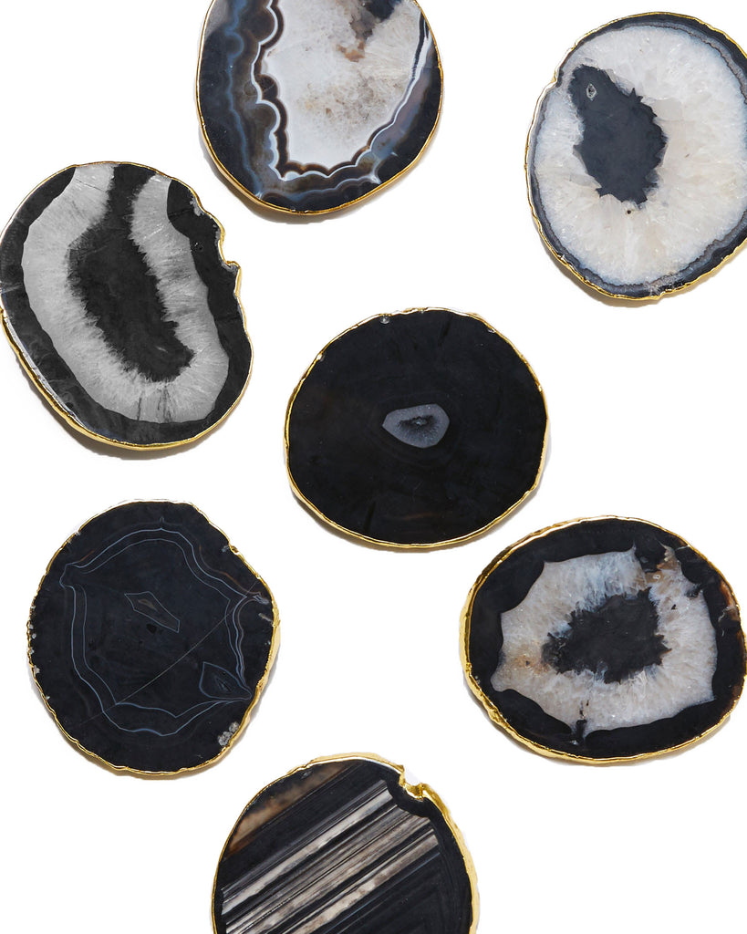 Gold plated black agate crystal coaster. Our natural crystal coasters are the perfect addition to your dining room or coffee table. With natural black agate from Brazil, coated in yellow gold plating, this coaster is an easy way to elevate the luxury in your home.   Black Agate Crystal   80-120 mm   Yellow Gold Plating  Please note: Due to our crystals being 100% natural, shape and colour patterns will vary.   