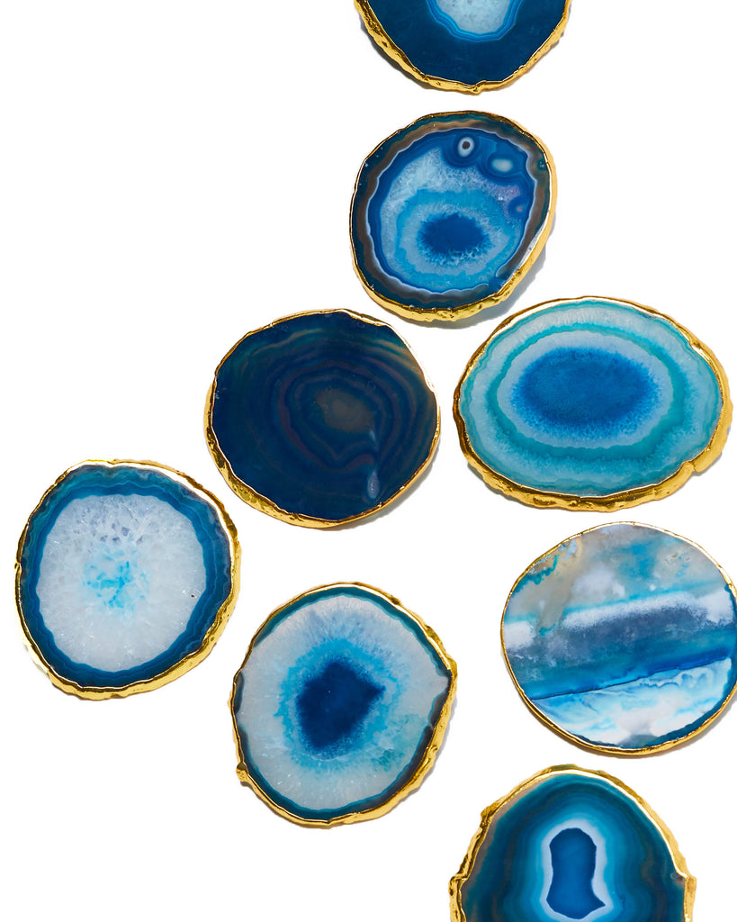 4 Gold Blue Agate Crystal Coasters  Our natural crystal coasters are the perfect addition to your dining room or coffee table. With natural blue agate from Brazil, coated in yellow gold plating, this coaster is an easy way to elevate the luxury in your home.  Blue Agate Crystal  100-120mm  Gold Plating  Please note: Due to our crystals being 100% natural, shape and colour patterns will vary.