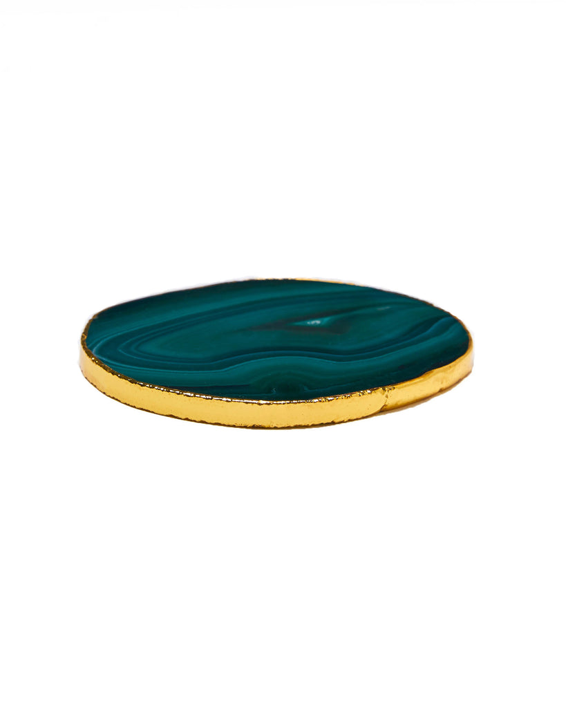 Gold plated green agate crystal coaster. Our natural crystal coasters are the perfect addition to your dining room or coffee table. With natural green agate from Brazil, coated in yellow gold plating, this coaster is an easy way to elevate the luxury in your home.   Green Agate Crystal   80-120mm   Yellow Gold Plating  Please note: Due to our crystals being 100% natural, shape and colour patterns will vary.   