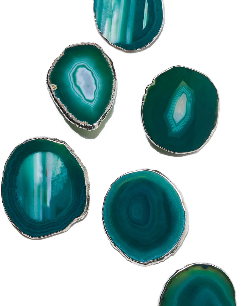 Silver plated green agate crystal coaster. Our natural crystal coasters are the perfect addition to your dining room or coffee table. With natural green agate from Brazil, coated in silver plating, this coaster is an easy way to elevate the luxury in your home.   Green Agate Crystal   80-120mm   Silver Plating  Please note: Due to our crystals being 100% natural, shape and colour patterns will vary.