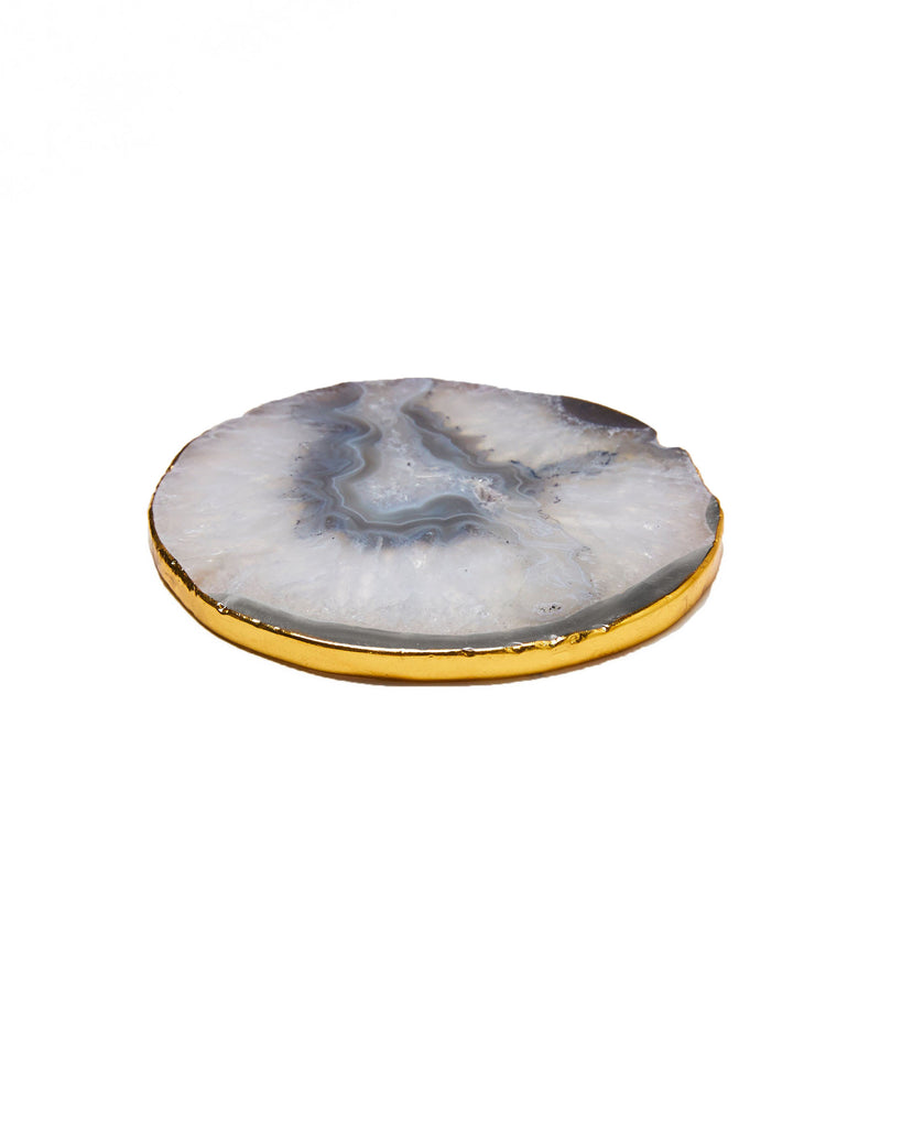 Gold plated grey agate crystal coaster. Our natural crystal coasters are the perfect addition to your dining room or coffee table. With natural grey agate, coated in gold plating, this coaster is an easy way to elevate the luxury in your home.  Grey Agate Crystal  80-120mm  Gold Plating  Please note: Due to our crystals being 100% natural, shape and colour patterns will vary.